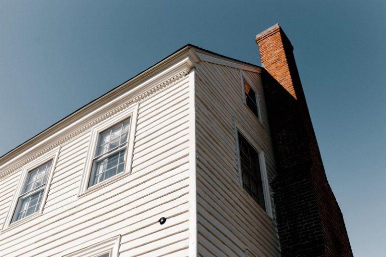 Brick chimney on the side of a house.